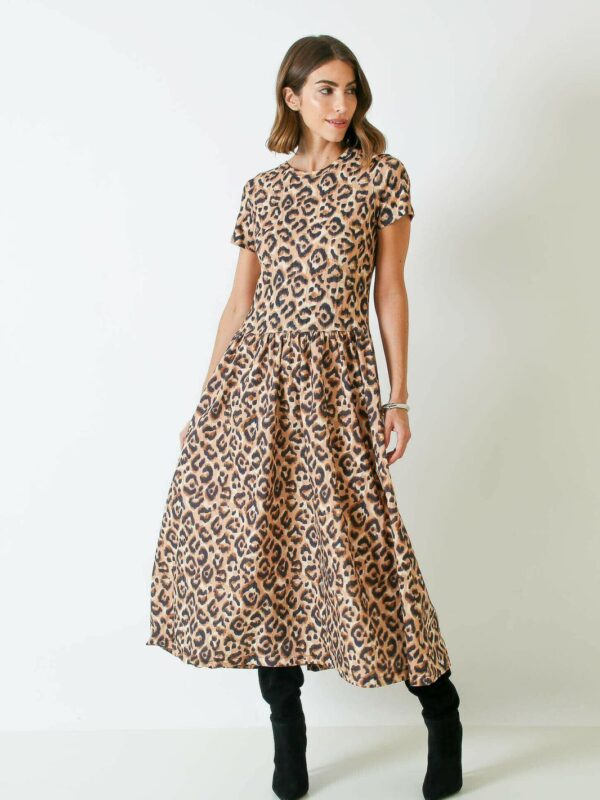 Vestido midi comprimento ao meio da panturrilha com mangas médias ao meio do bíceps e peito completamente coberto. Forma justa no busto e saia fluida nas pernas.