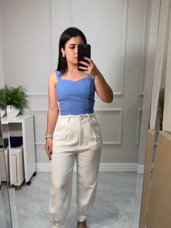 Blusa azul justa em tecido mais grosso e com mínimo decote. Possui alças largas.